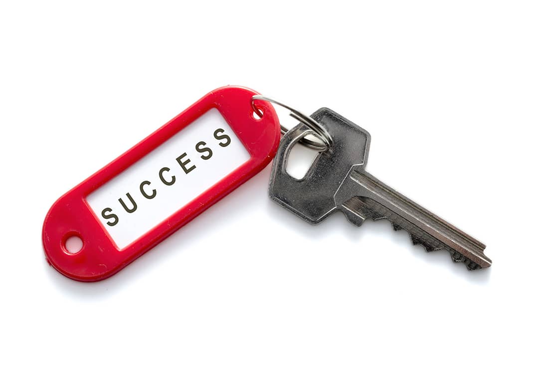A Key With a Red keyholder With The Word Success Written On It